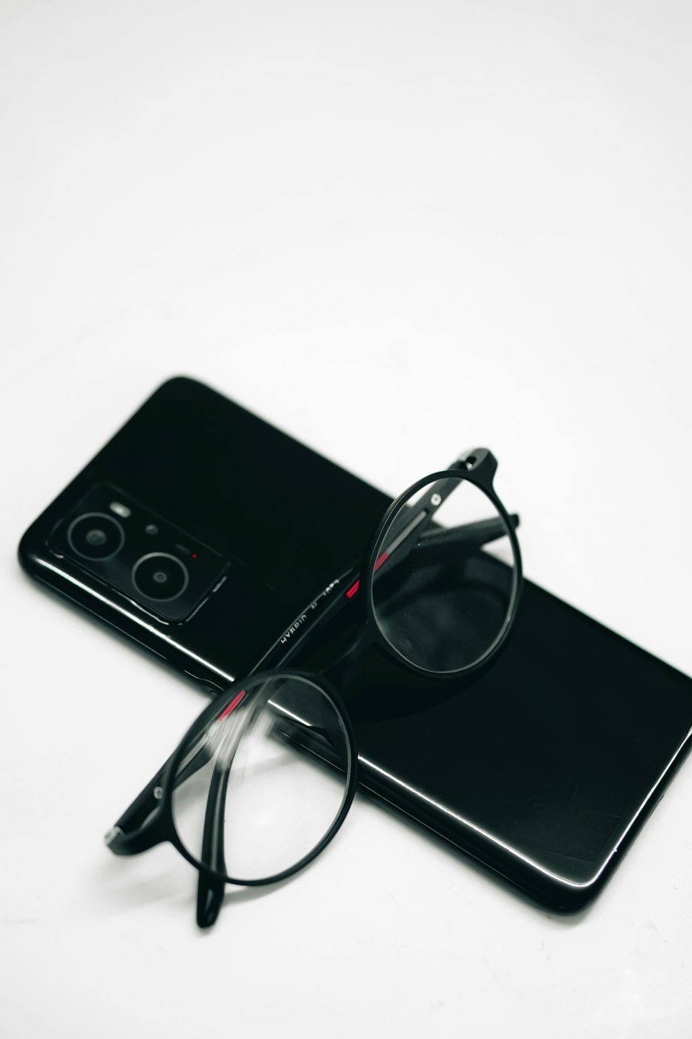 a pair of glasses sitting on top of a phone