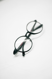 a pair of glasses sitting on top of a white table