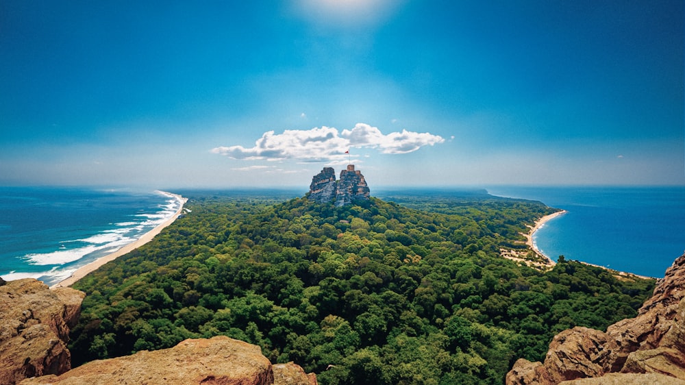 an aerial view of a mountain with a beach in the background