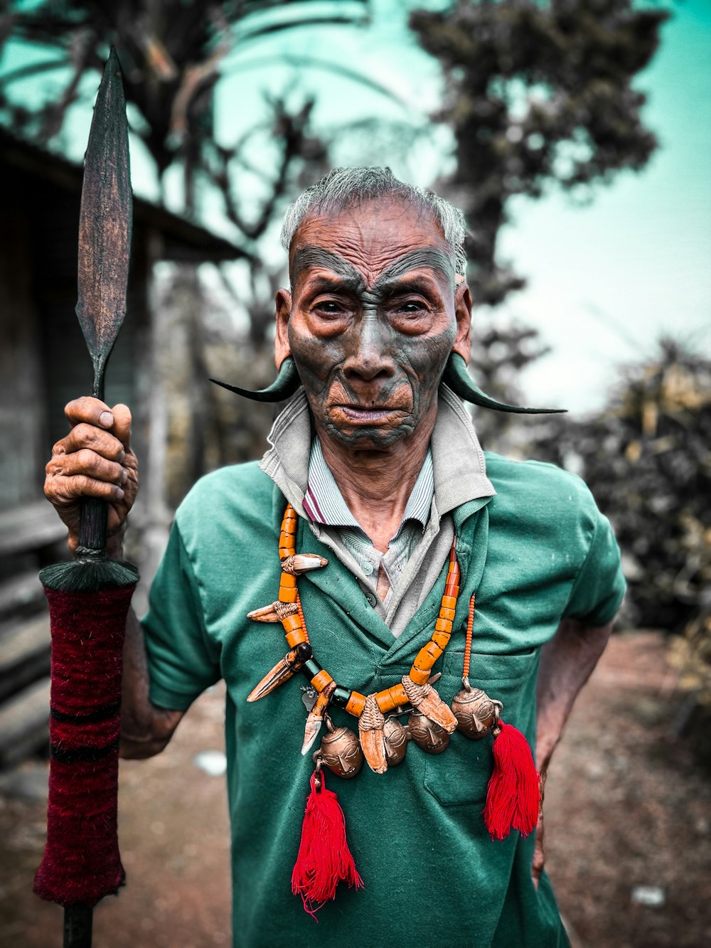 a man in a green shirt holding a large knife