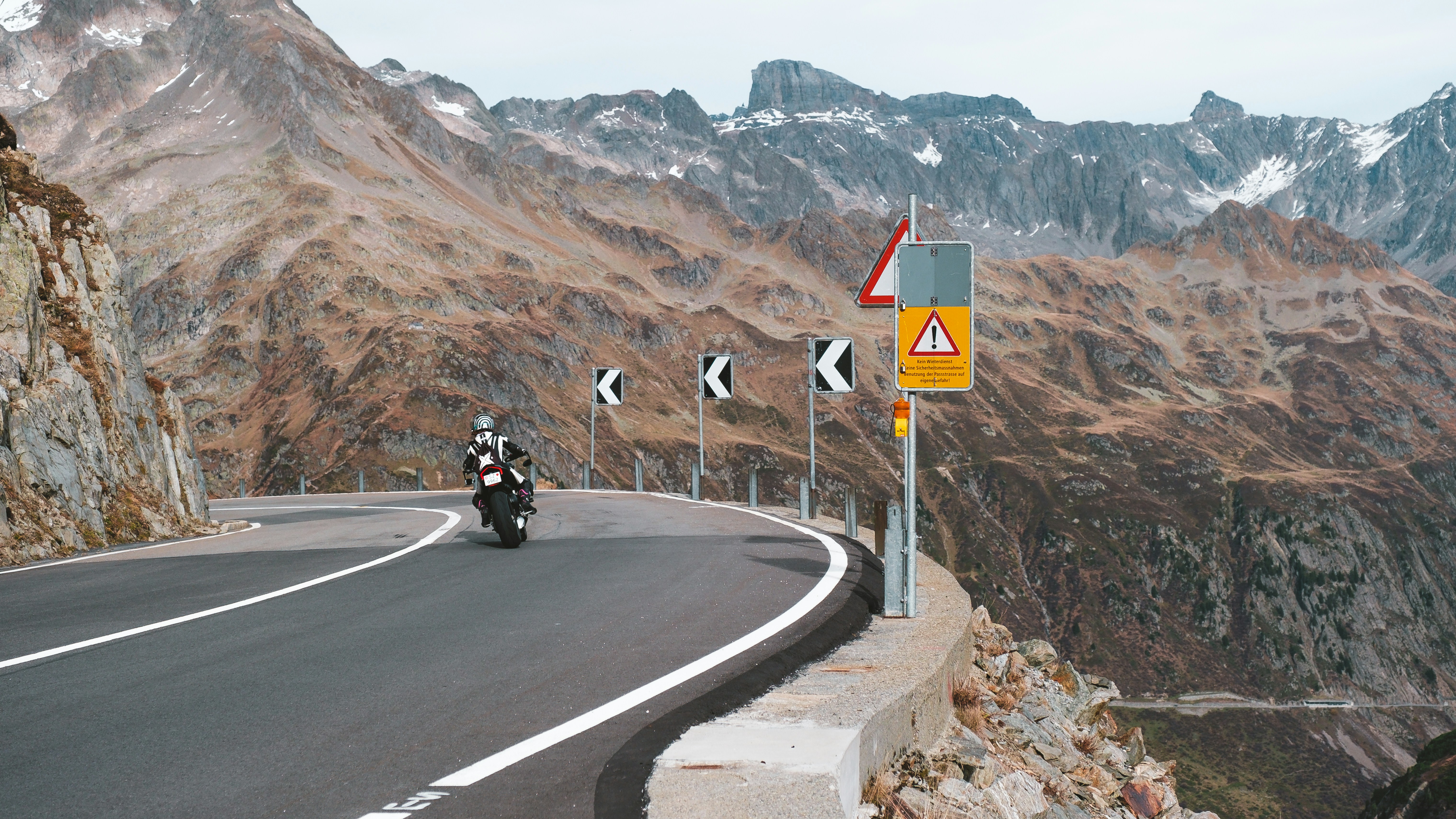 a person riding a motorcycle on a mountain road