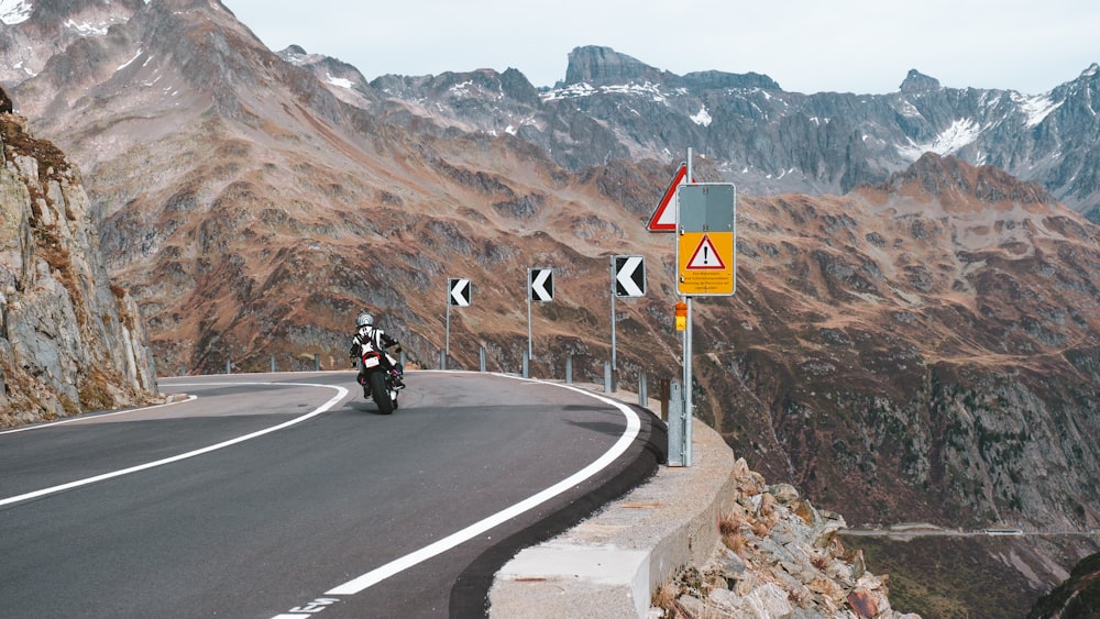 a person riding a motorcycle on a mountain road