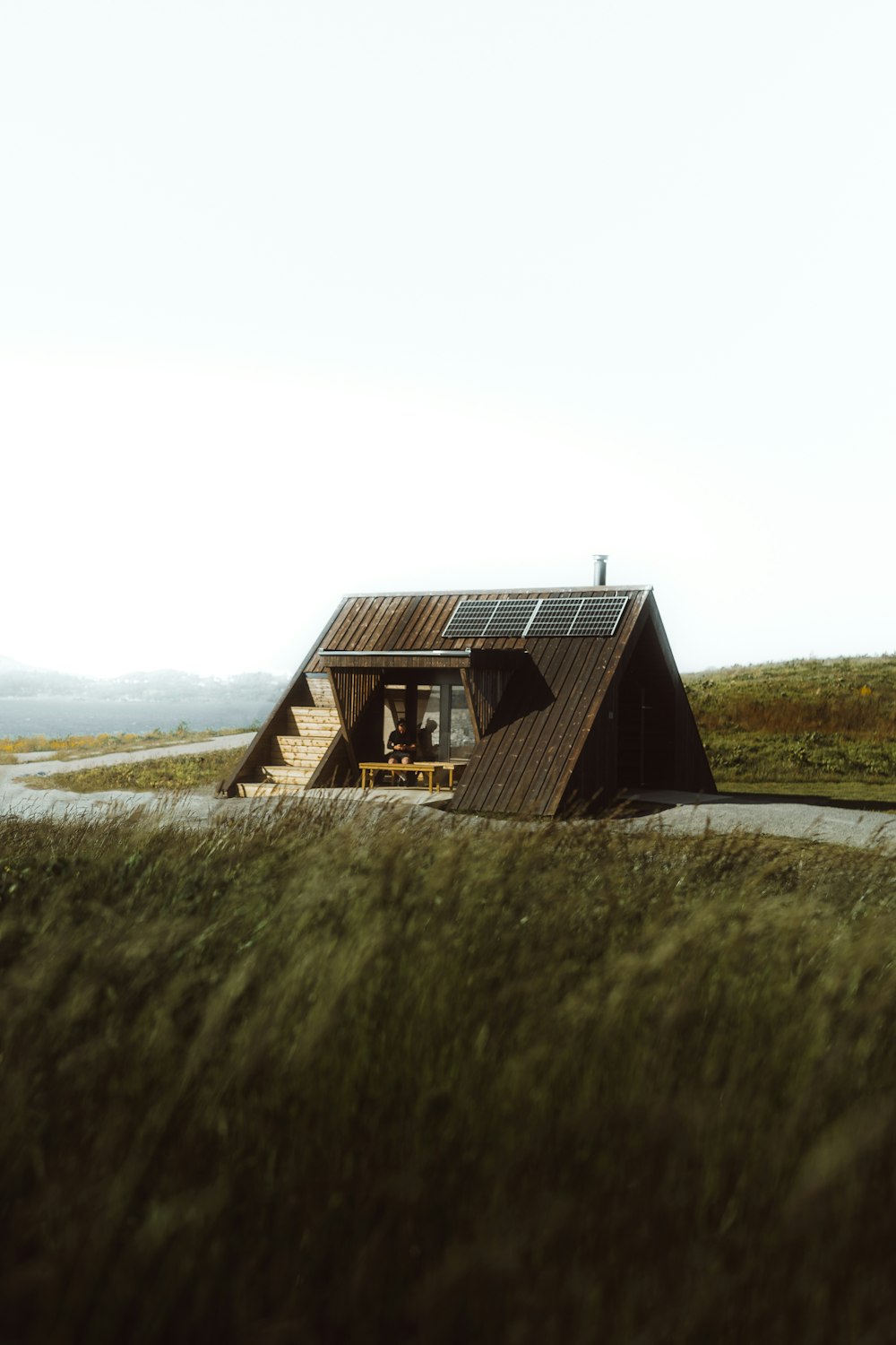 a small cabin in the middle of a grassy field