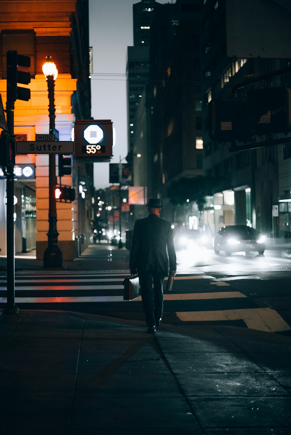 a man walking across a street at night