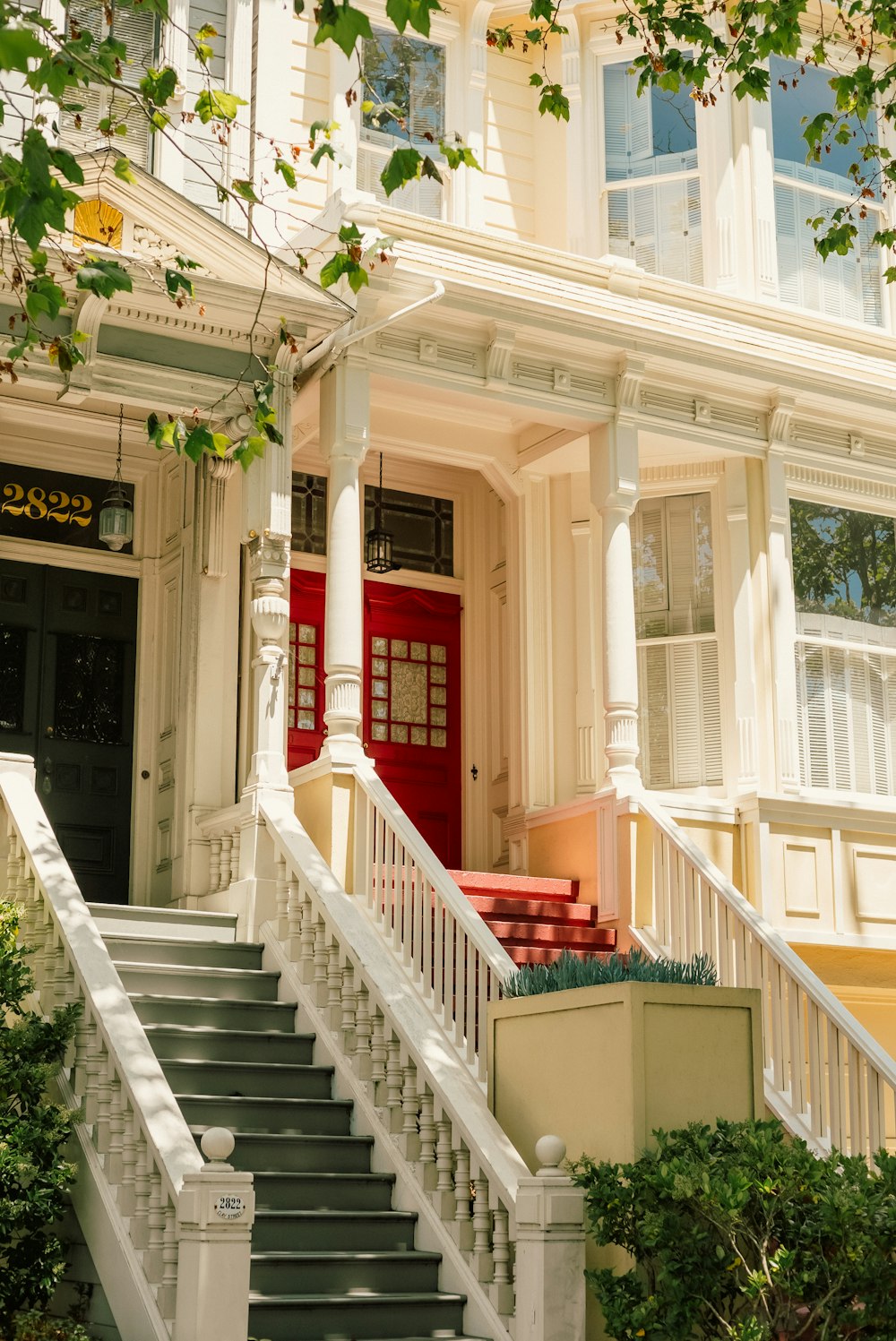 a white house with a red door and stairs