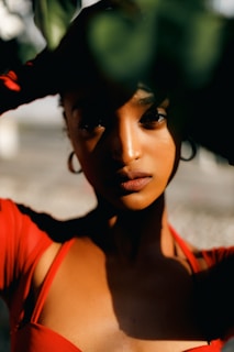 A model wearing earrings in a sunny outdoor setting.