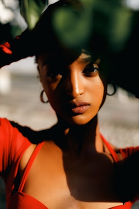 A model wearing earrings in a sunny outdoor setting.