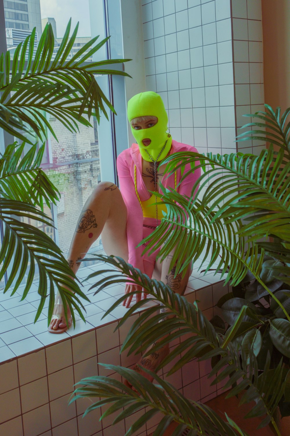 a man wearing a neon green mask and a pink shirt