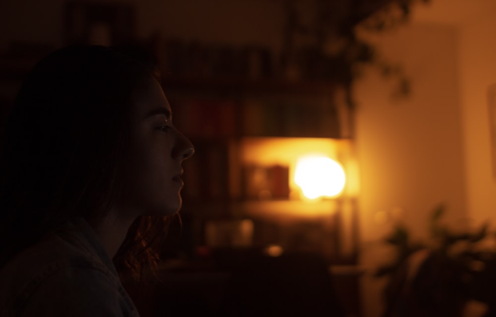 a woman standing in a living room at night