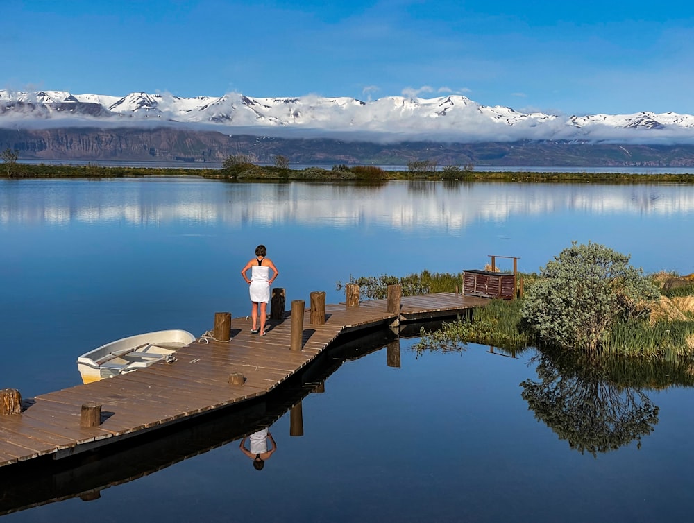 a woman standing on a dock next to a boat