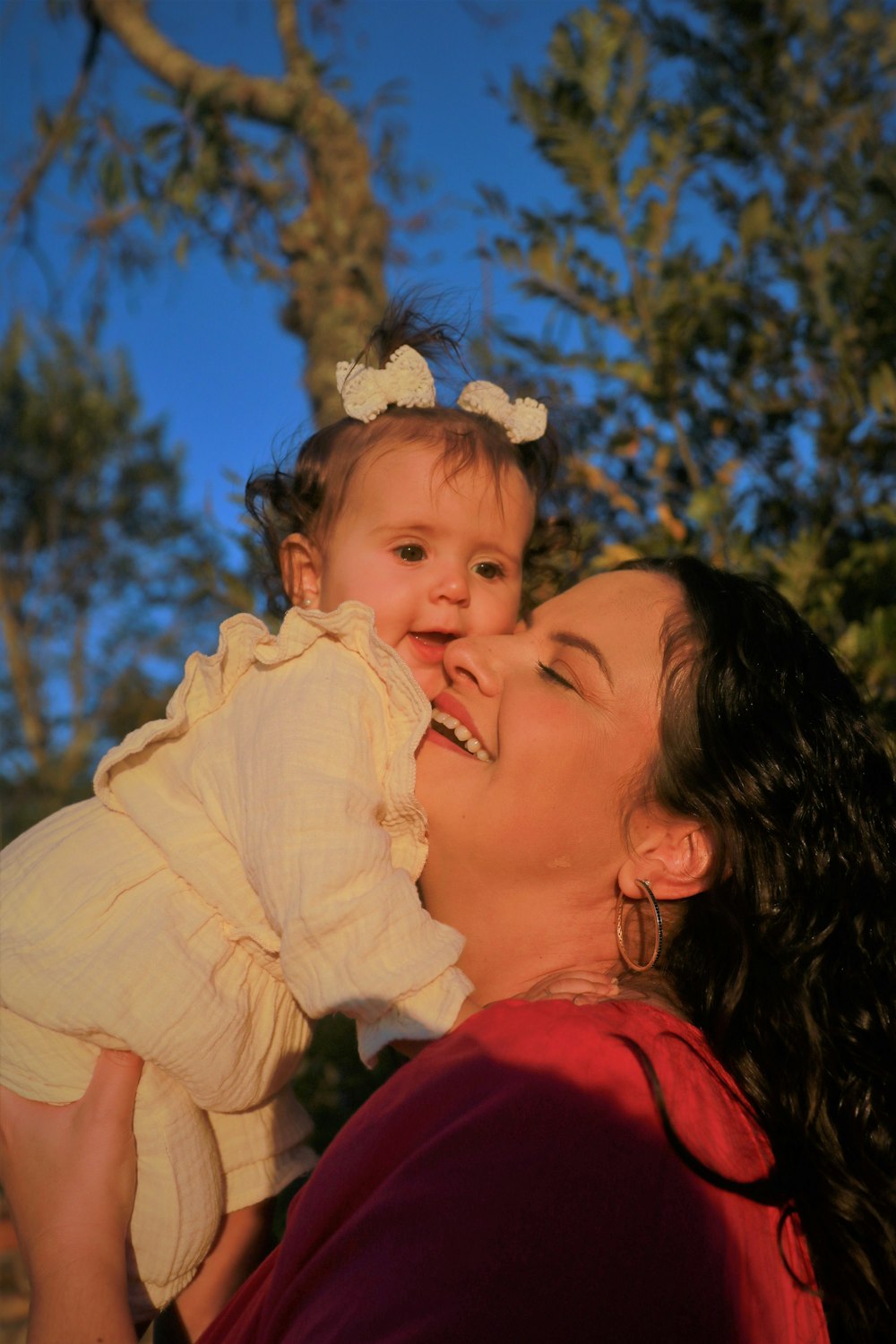 a woman holding a baby up to her face