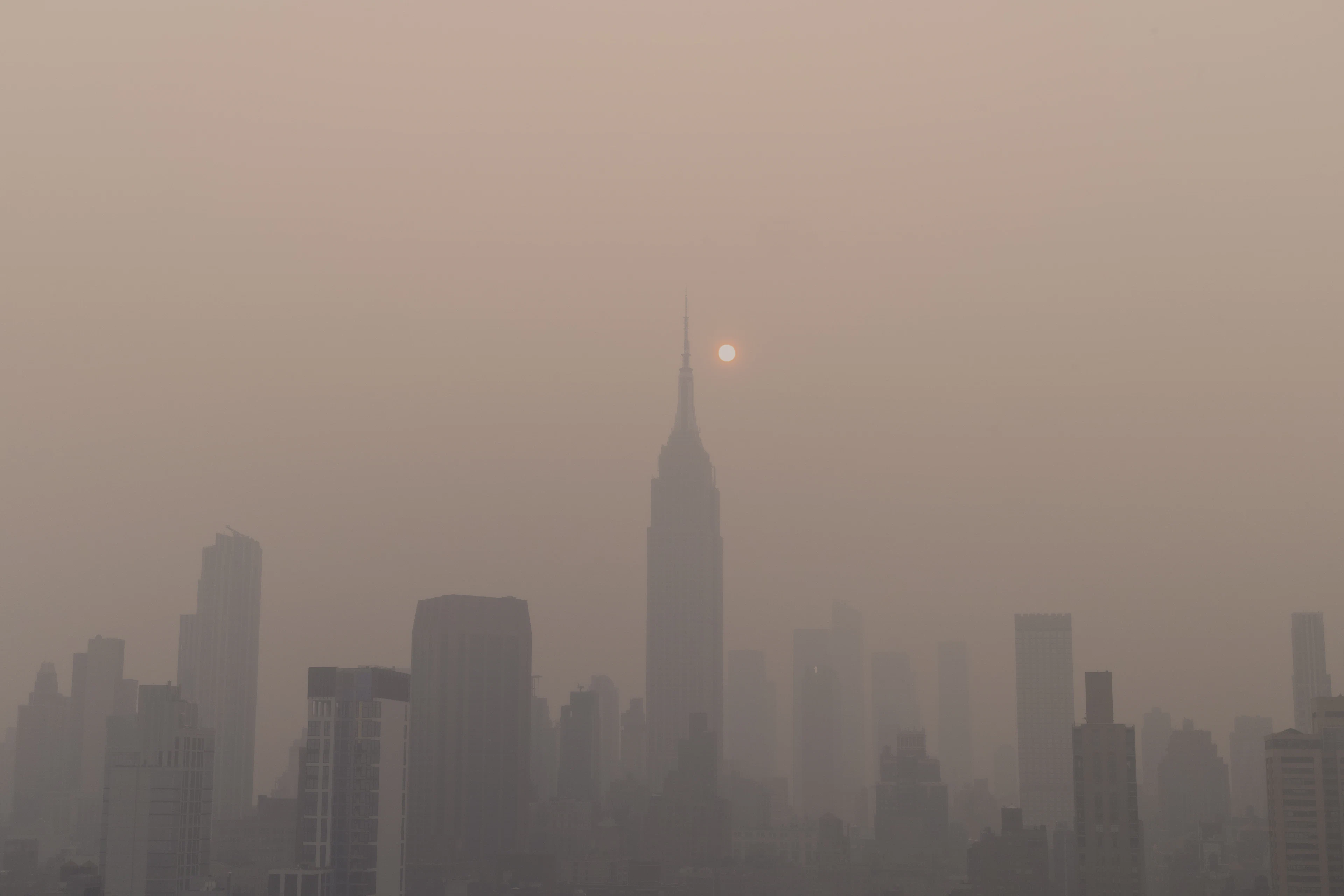 Foggy city skyline with the sun in the distance
