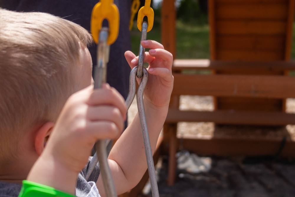 a little boy holding onto a pair of scissors