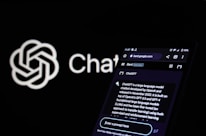 A smartphone displays a webpage related to ChatGPT, showcasing details about the language model and its development. The screen shows text explaining ChatGPT's capabilities and origins. In the background, a logo with a neural network design and the word 'ChatGPT' are visible.