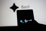 A hand holding a latest model smartphone with interactive star ratings visible on screen.