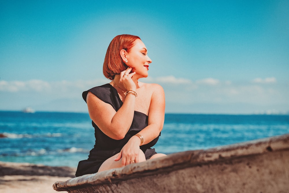 a woman sitting on a boat on the beach