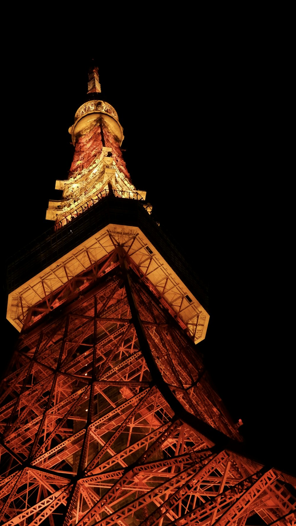the top of the eiffel tower lit up at night