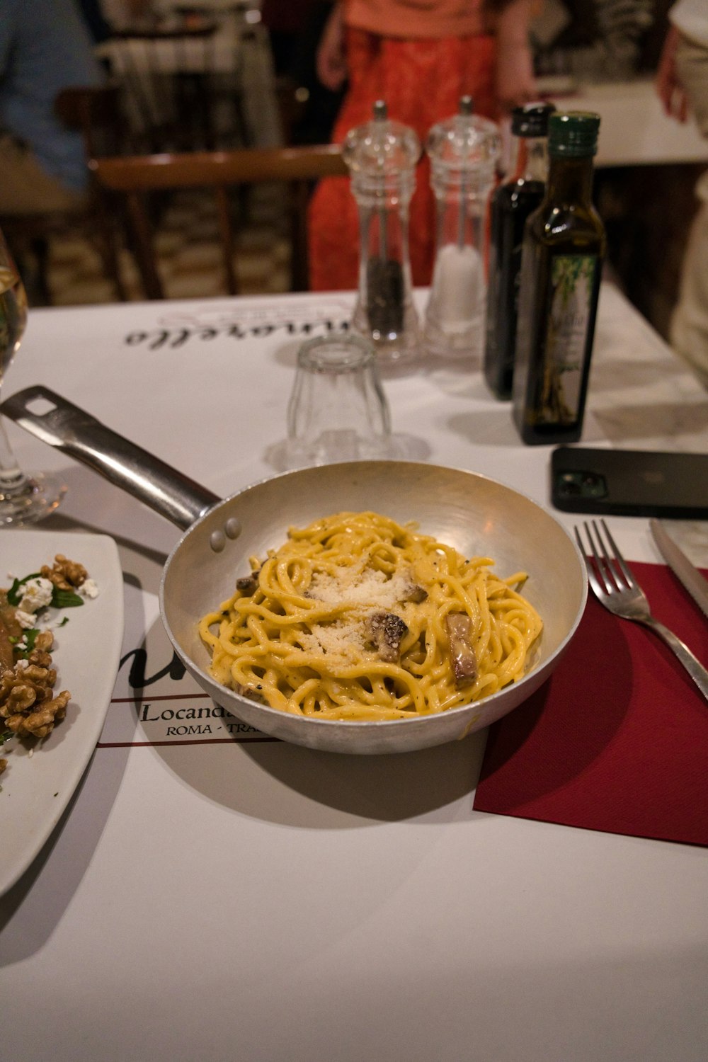 a plate of spaghetti and a glass of wine on a table