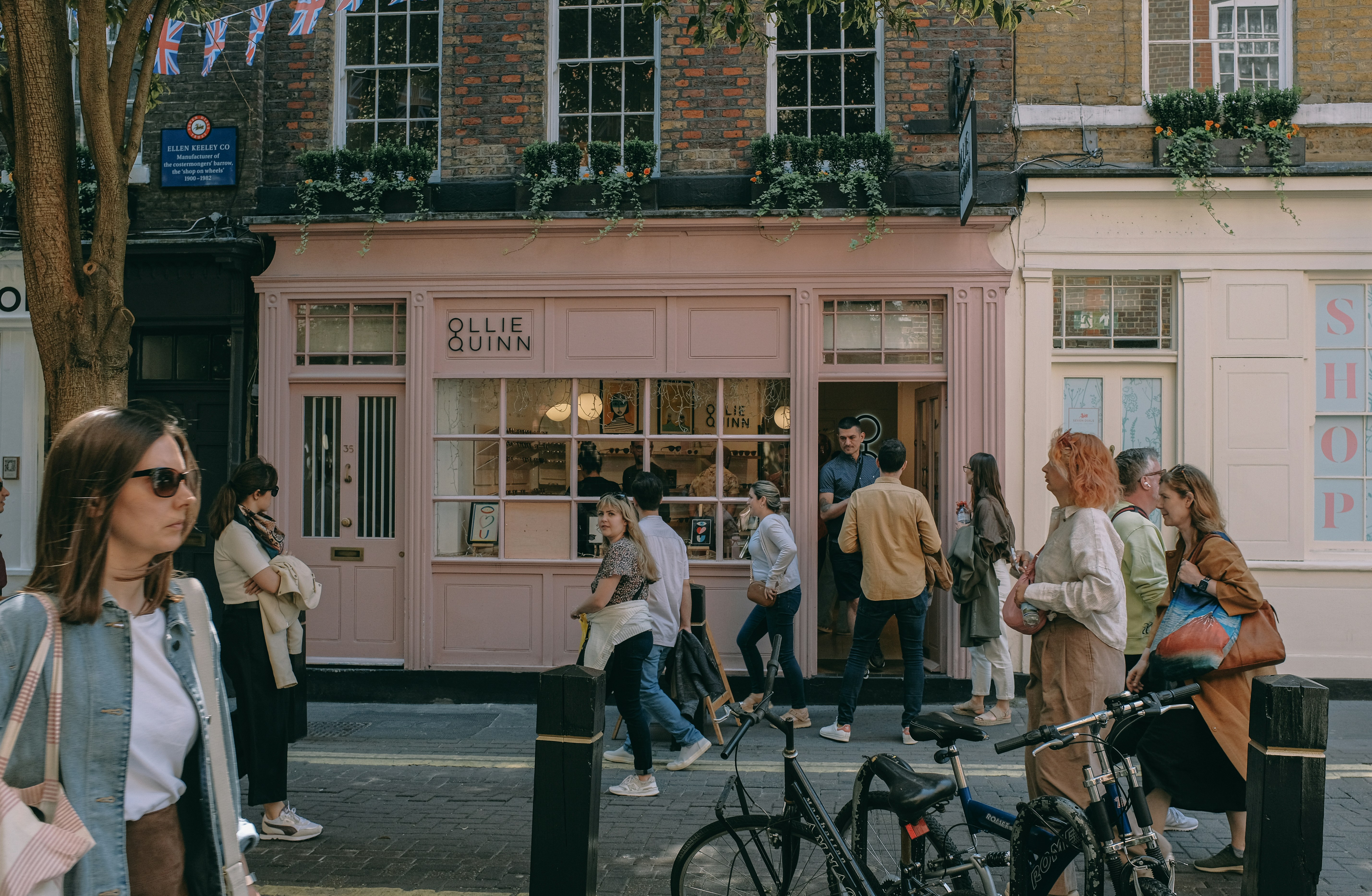 A group of people standing outside of a store photo – Free People Image ...