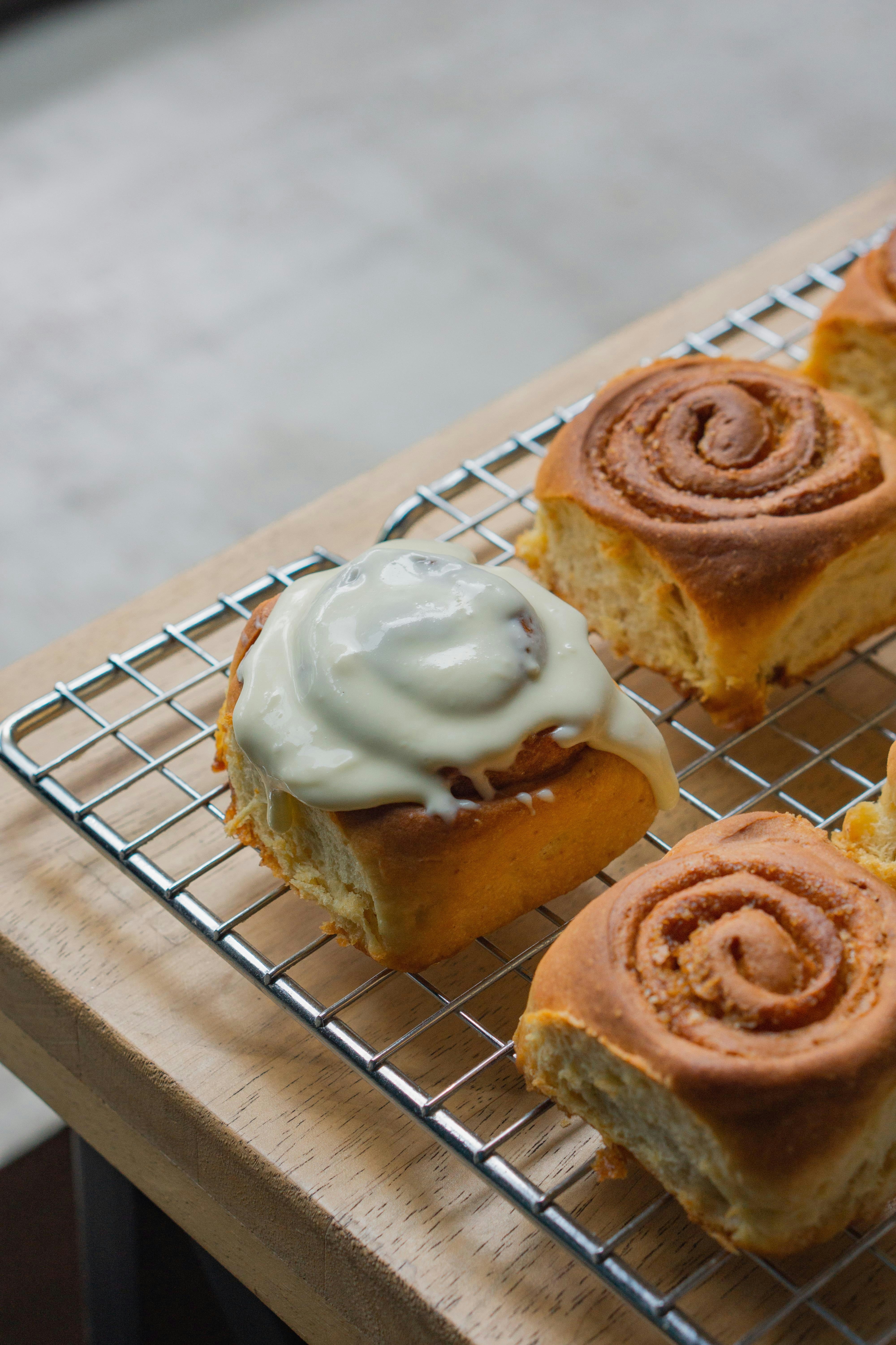 a metal rack holding pastries on top of a wooden table