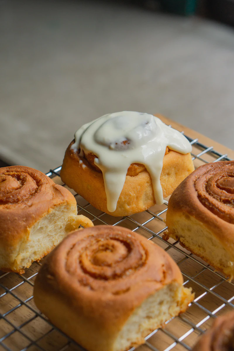 Frosted cinnamon rolls cooling on a wire rack