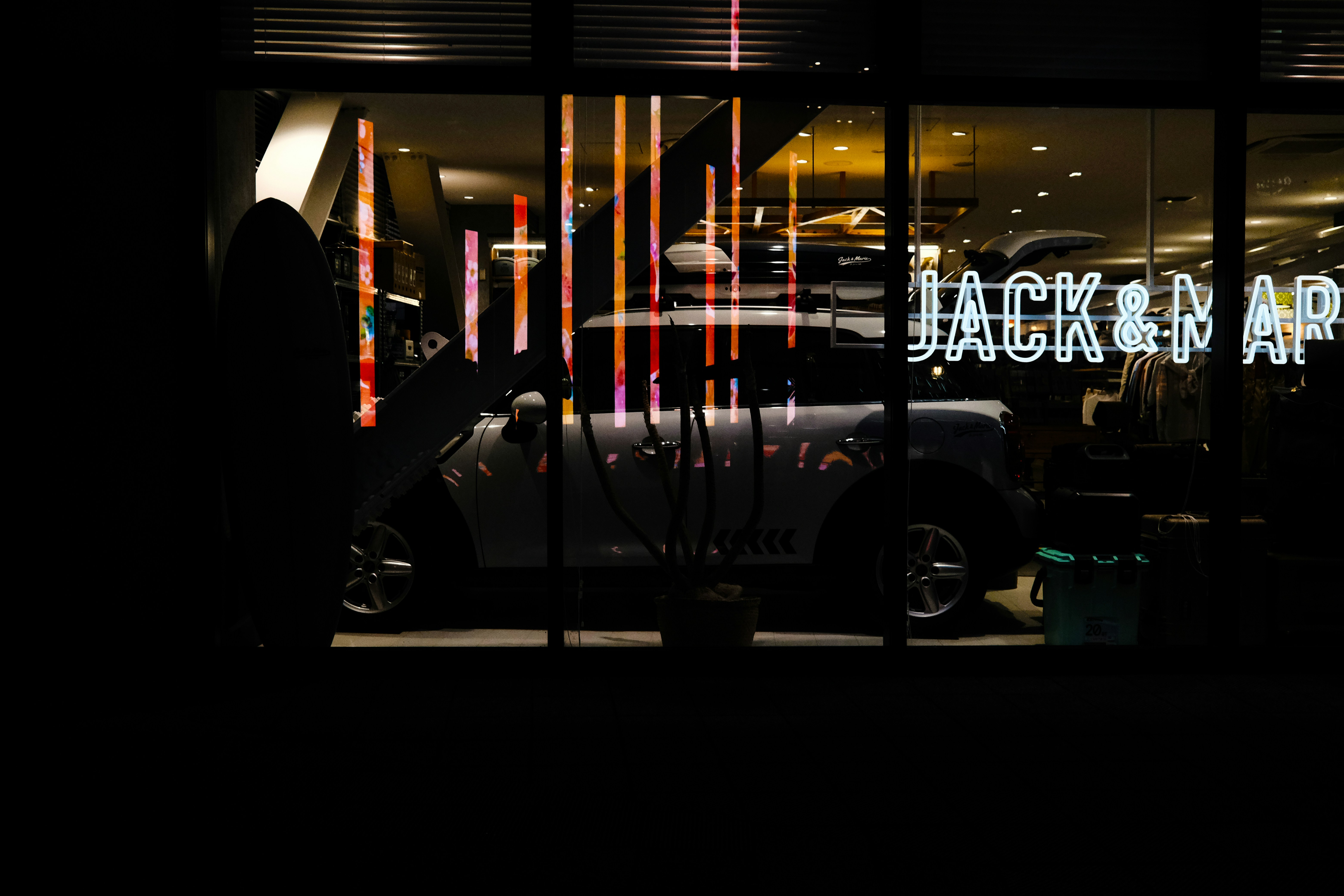 a car is parked in front of a store window