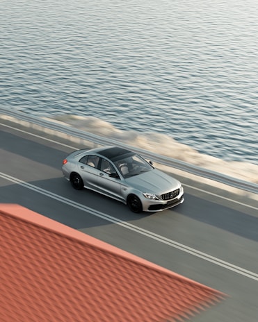 A Silver Raine Transportation vehicle driving smoothly along a scenic coastal highway.