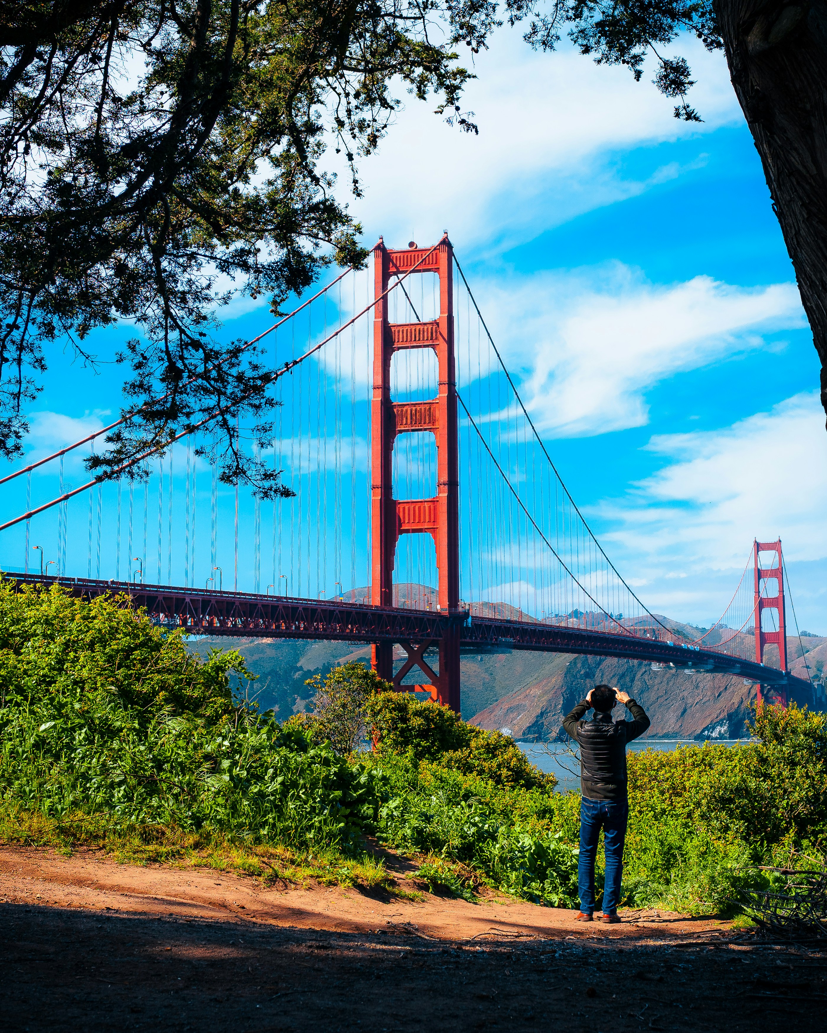 a man taking a picture of the golden gate bridge