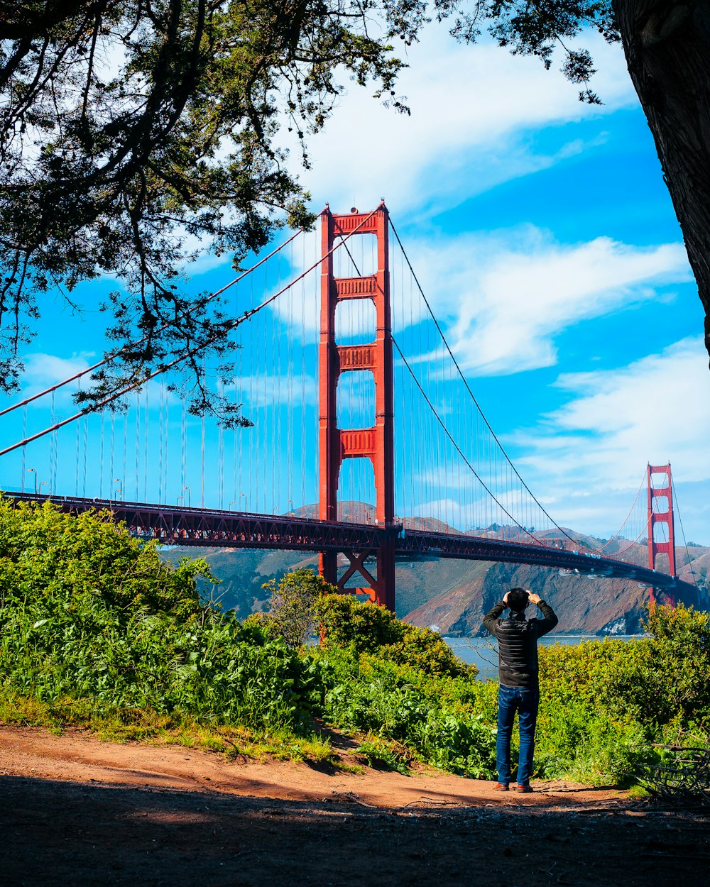 a man taking a picture of the golden gate bridge