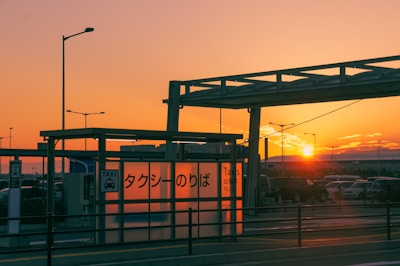 A professional taxi waiting outside Kuwait International Airport at sunset.