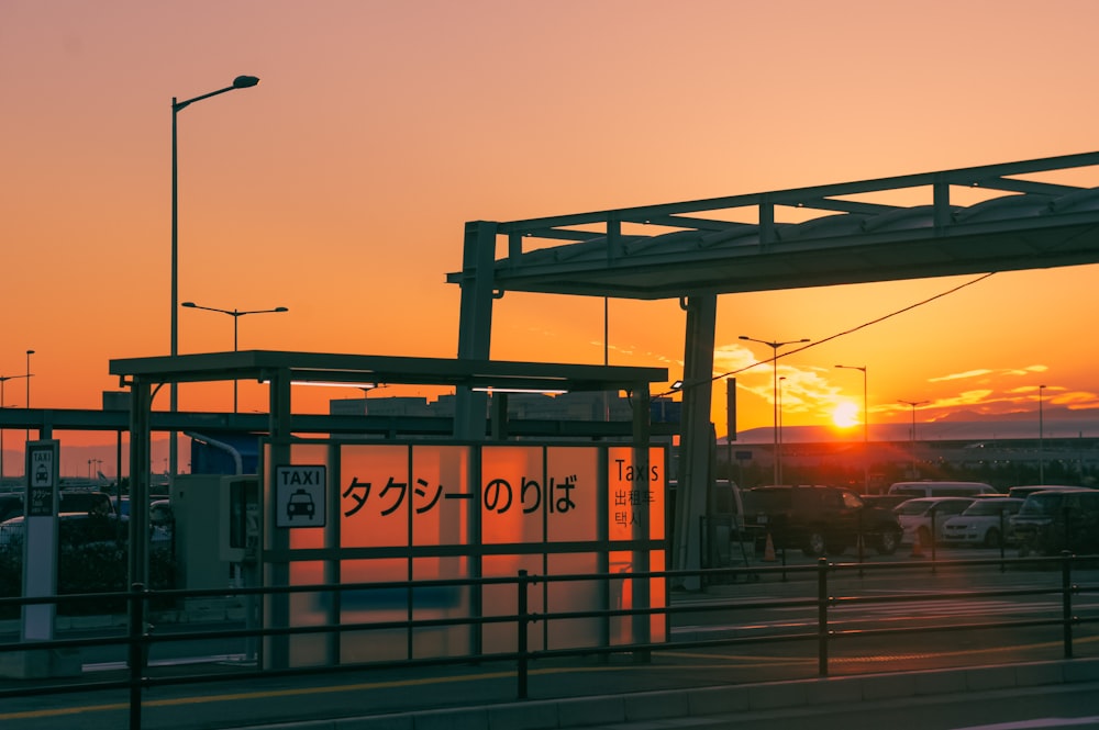 the sun is setting over a parking lot