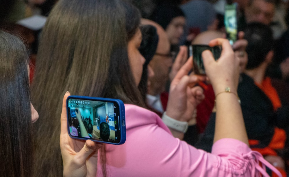 a group of people taking pictures with their cell phones