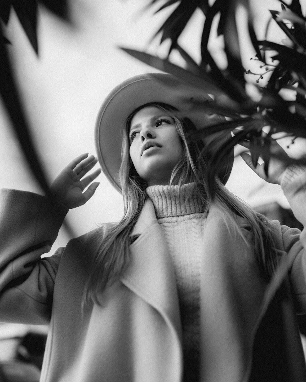 a black and white photo of a woman wearing a hat