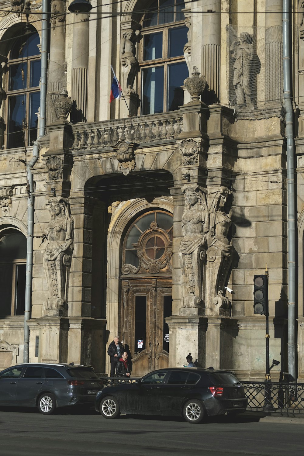 two cars parked in front of a large building