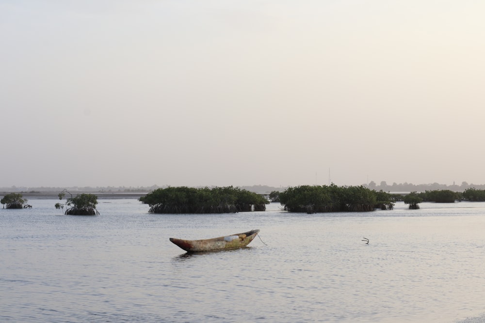 a small boat floating on top of a body of water