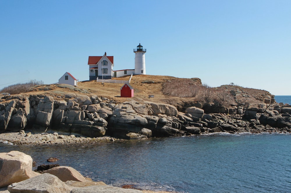 a lighthouse on a rocky island with a red door