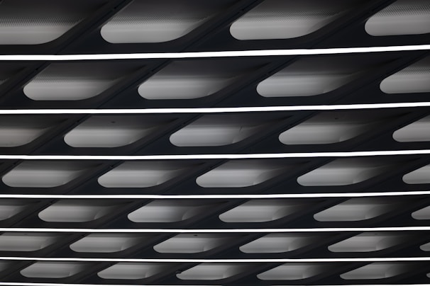 A close-up of a false ceiling design featuring geometric patterns and integrated LED strips.