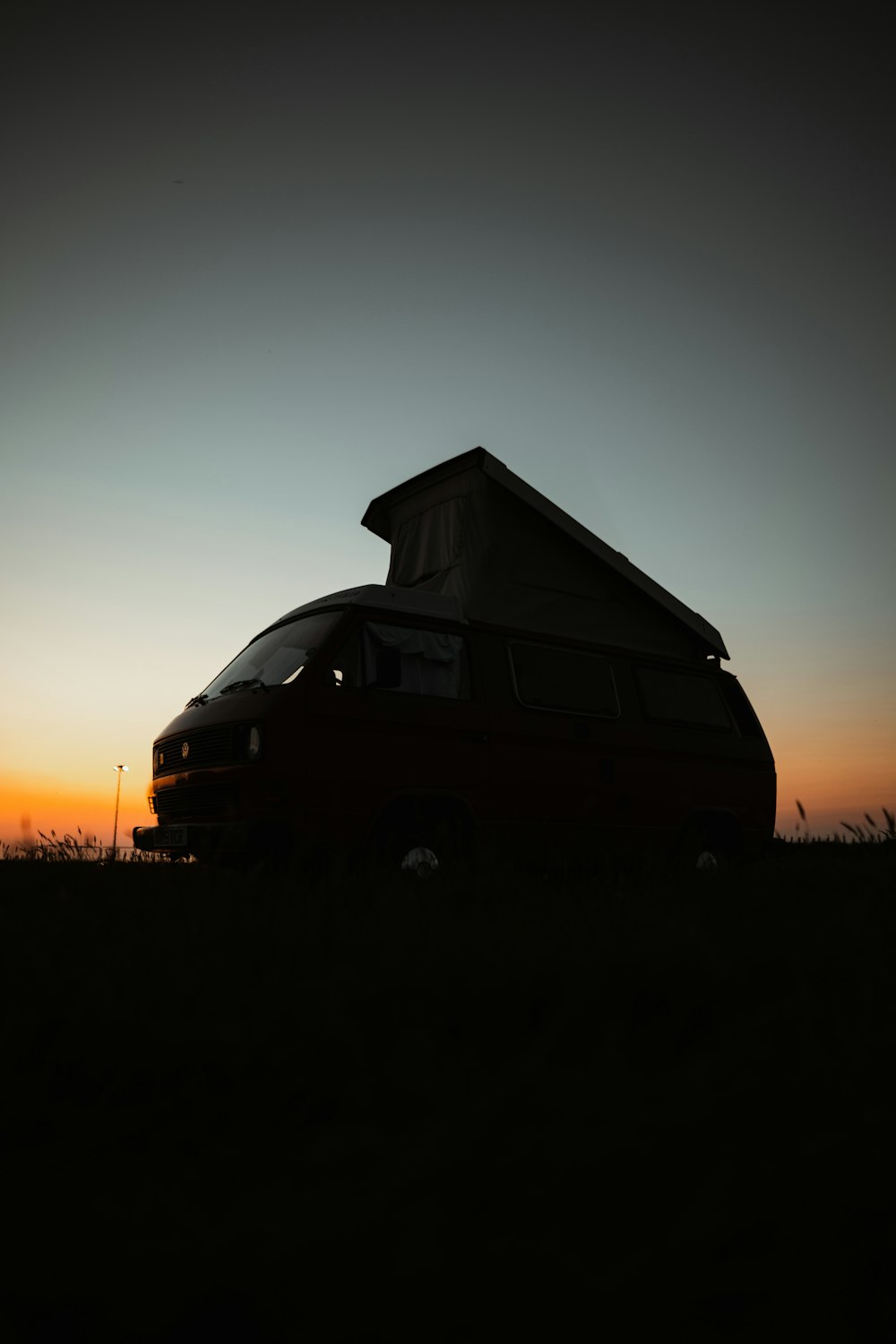 a van parked in a field at sunset