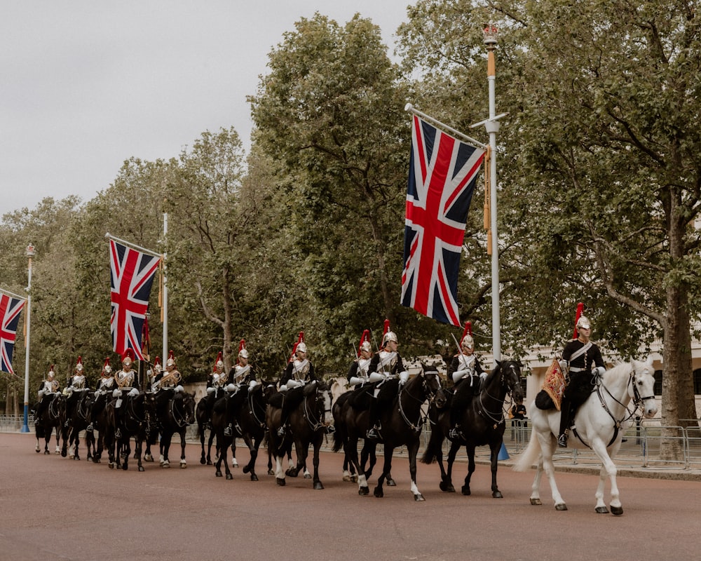 a group of people riding horses down a street