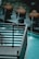 The image contains a decorative outdoor water feature with several spherical terracotta pots, each streaming water into a pool. The water is a striking turquoise, contrasting with the dark metal railing in the foreground.