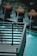 The image contains a decorative outdoor water feature with several spherical terracotta pots, each streaming water into a pool. The water is a striking turquoise, contrasting with the dark metal railing in the foreground.