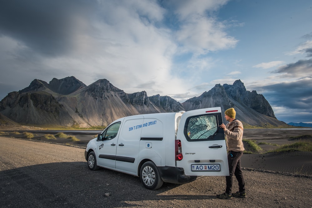 a man standing next to a white van