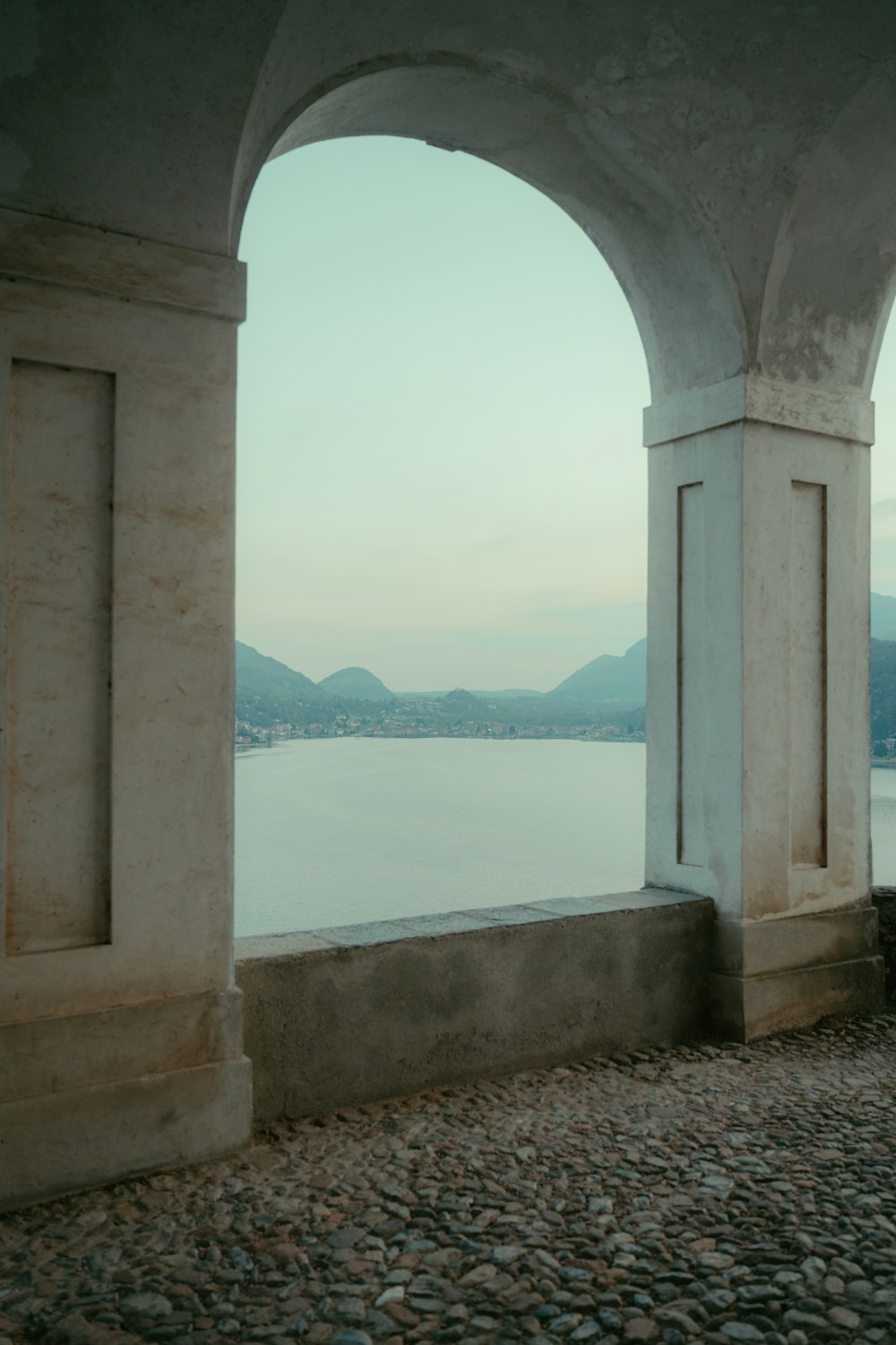 a view of a body of water through two archways