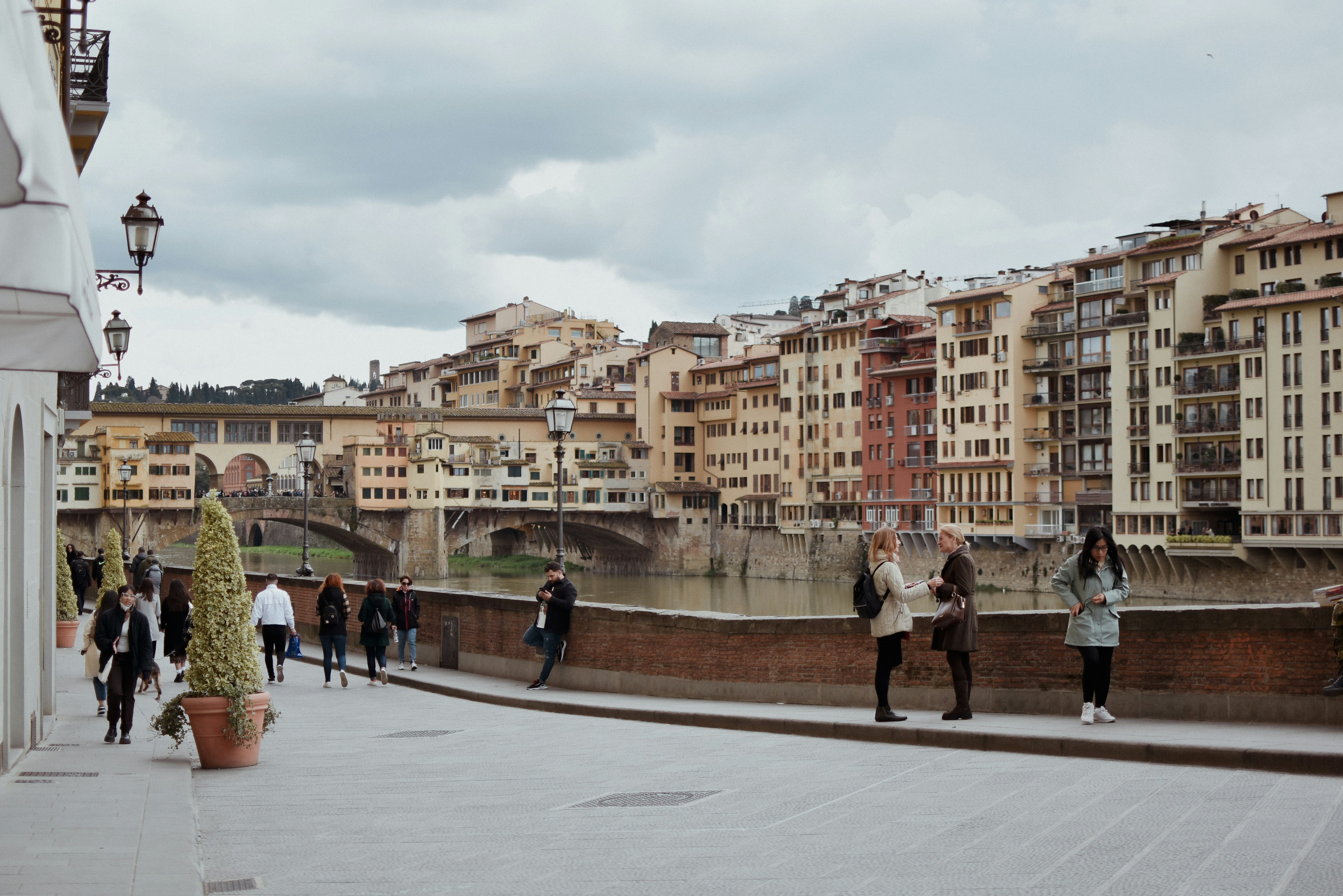 A group of people walking on a bridge over a river