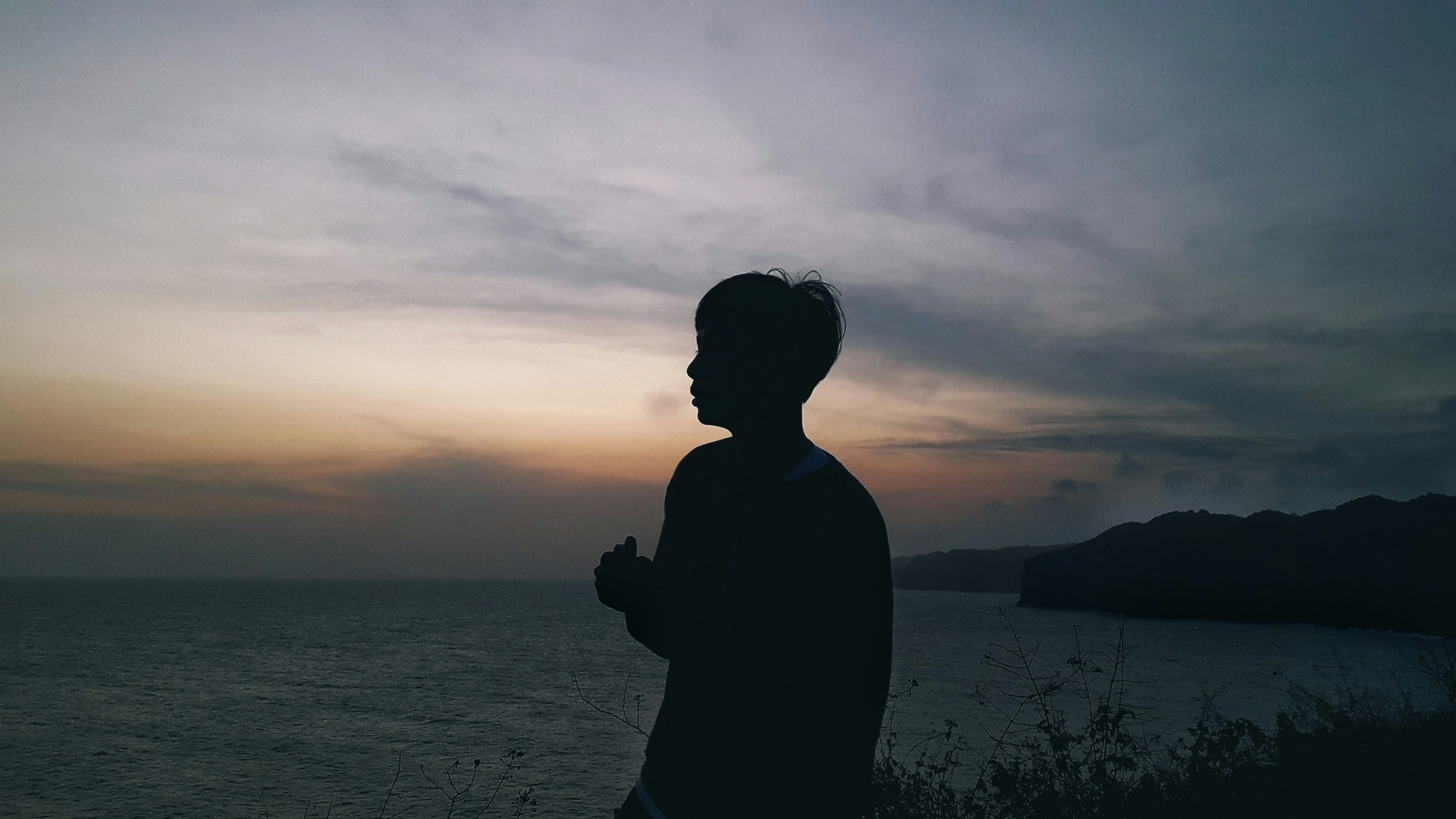 a man standing in front of a body of water