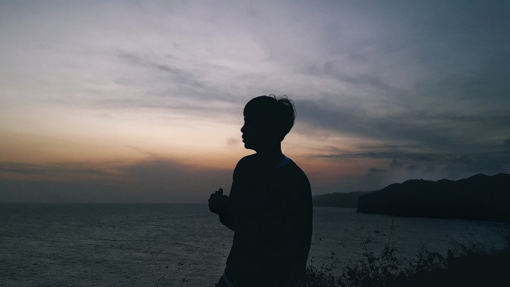 a man standing in front of a body of water