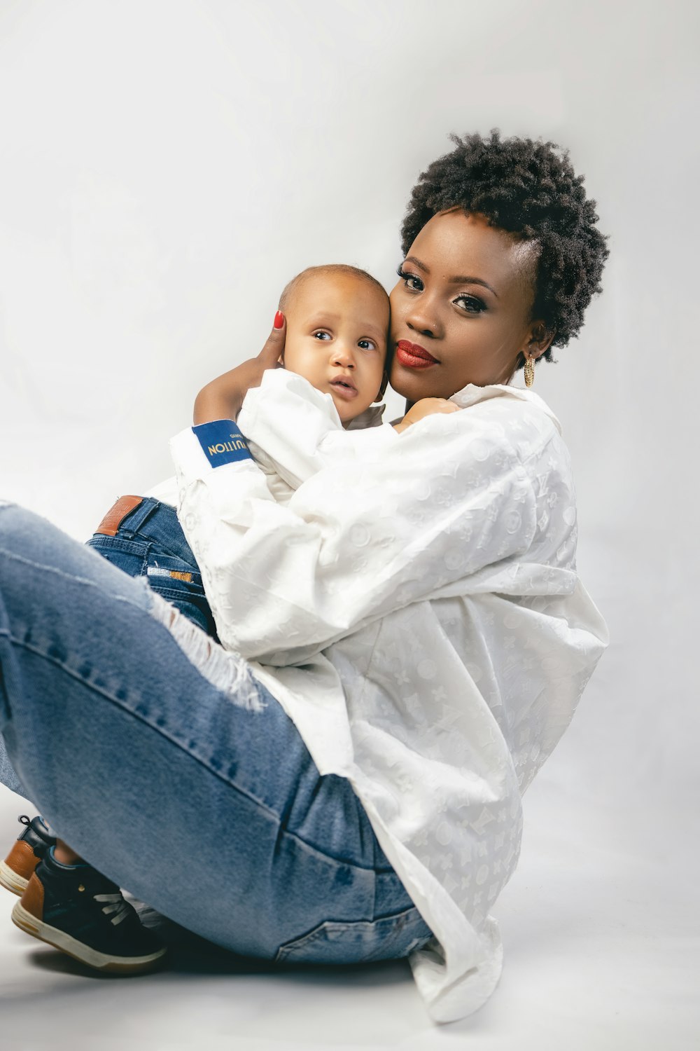 a woman sitting on the ground holding a baby