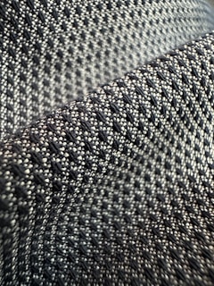 Close-up of a black and white textile pattern featuring the recurring eye motif subtly integrated.