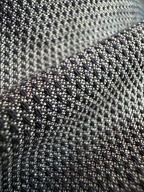 Detail shot of intricate weave patterns on a black than cloth fabric.
