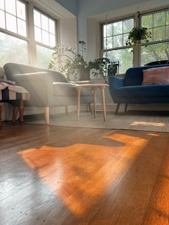 A bright and tidy living room with sunlight streaming through the windows.